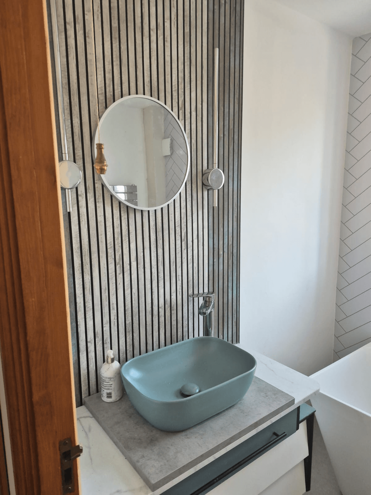 Sage green vessel basin with round mirror and slatted wall panel