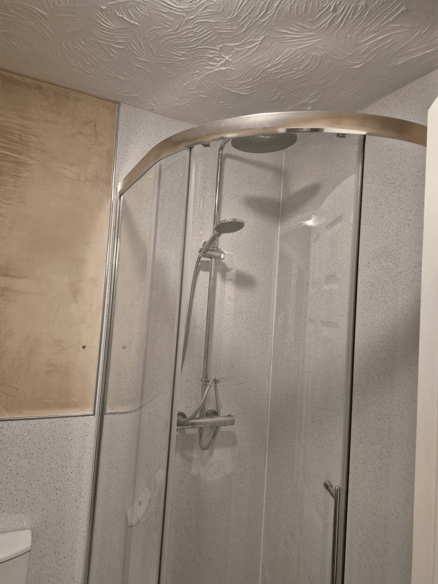 Corner shower enclosure with curved glass doors