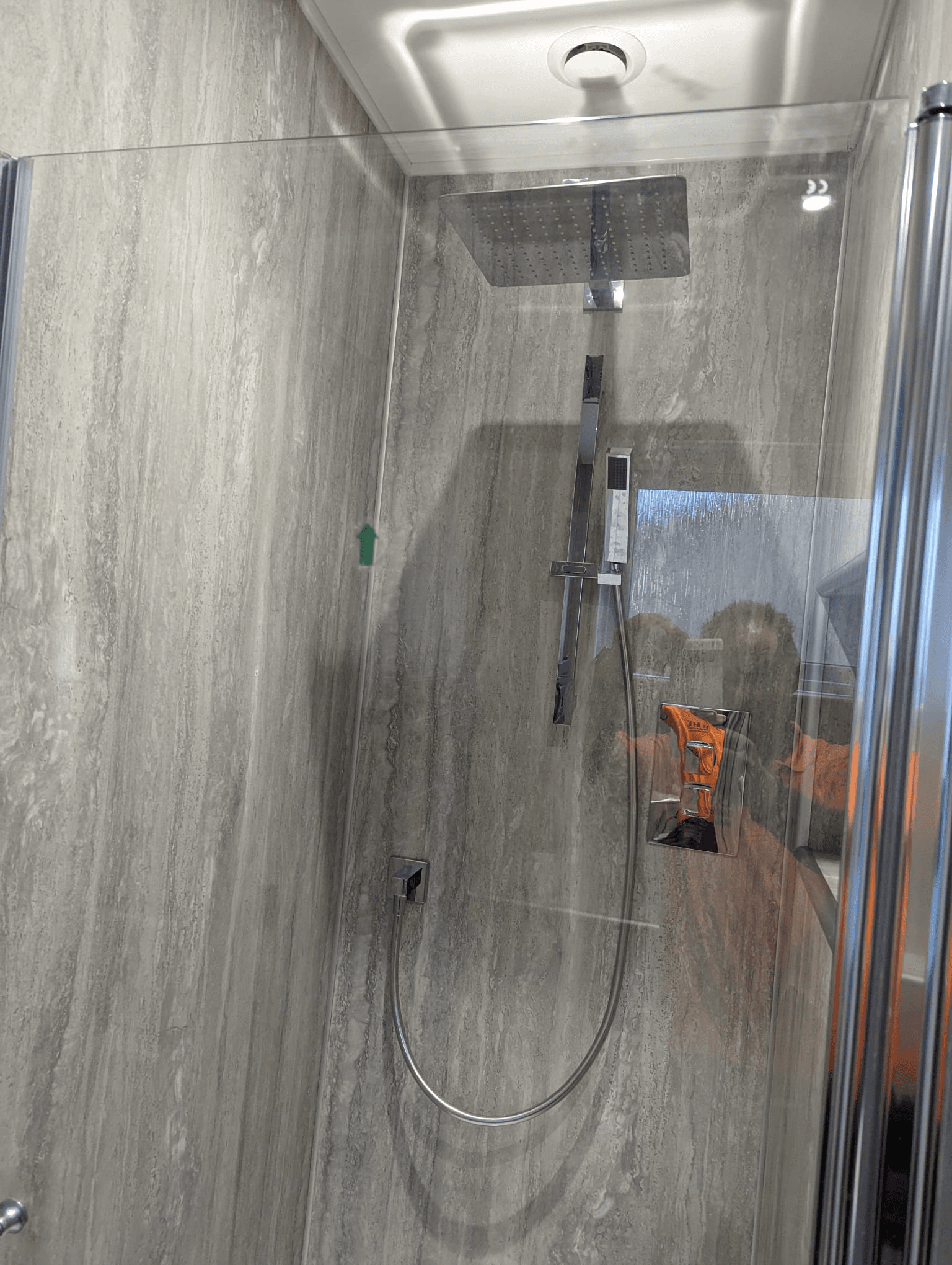 Shower enclosure with large grey stone-effect panels and square overhead rainfall shower head
