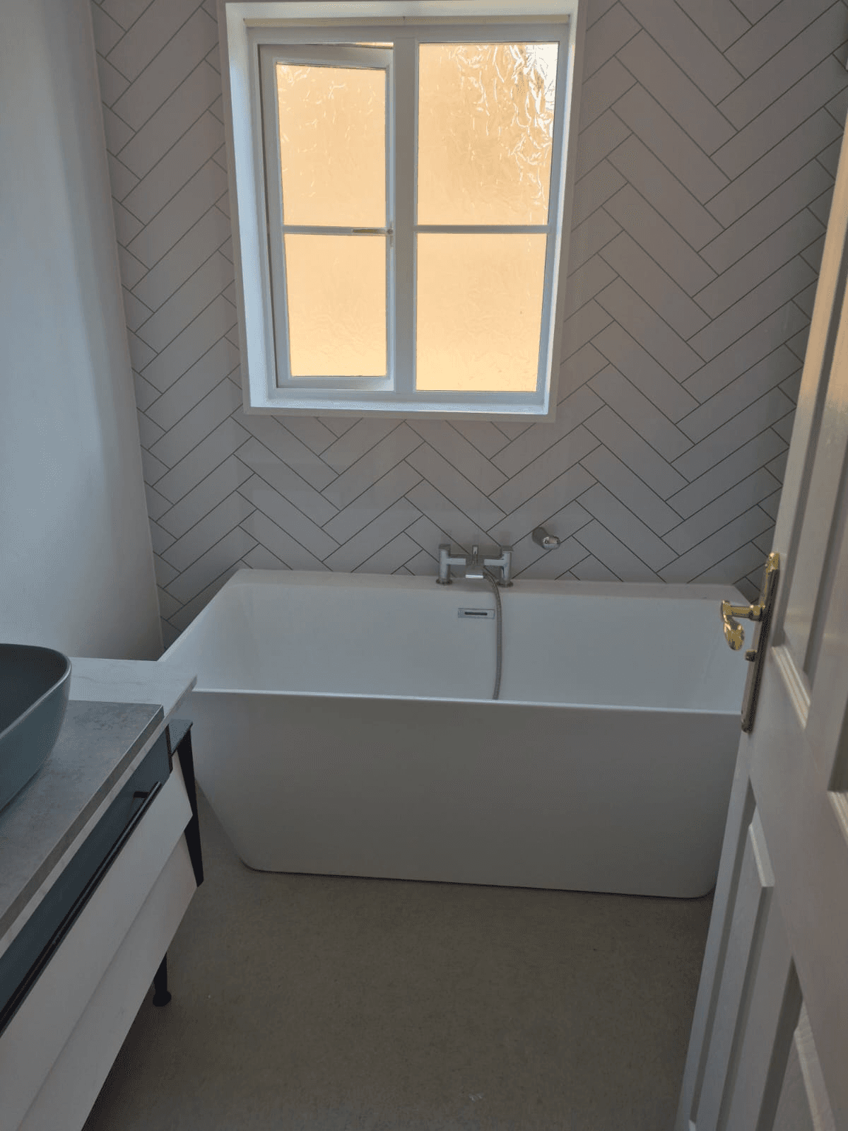 Herringbone tiles with freestanding bath