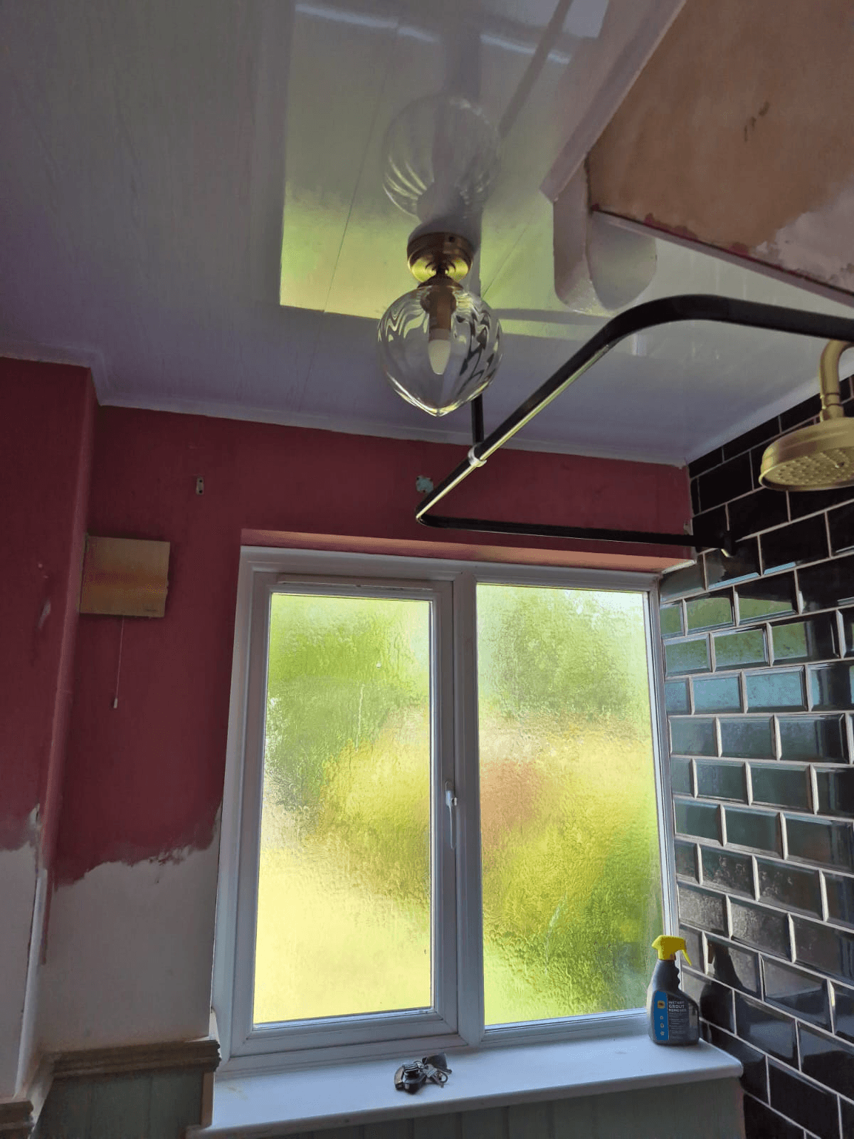 Dark metro tiles being installed — ceiling and wall tiling in progress