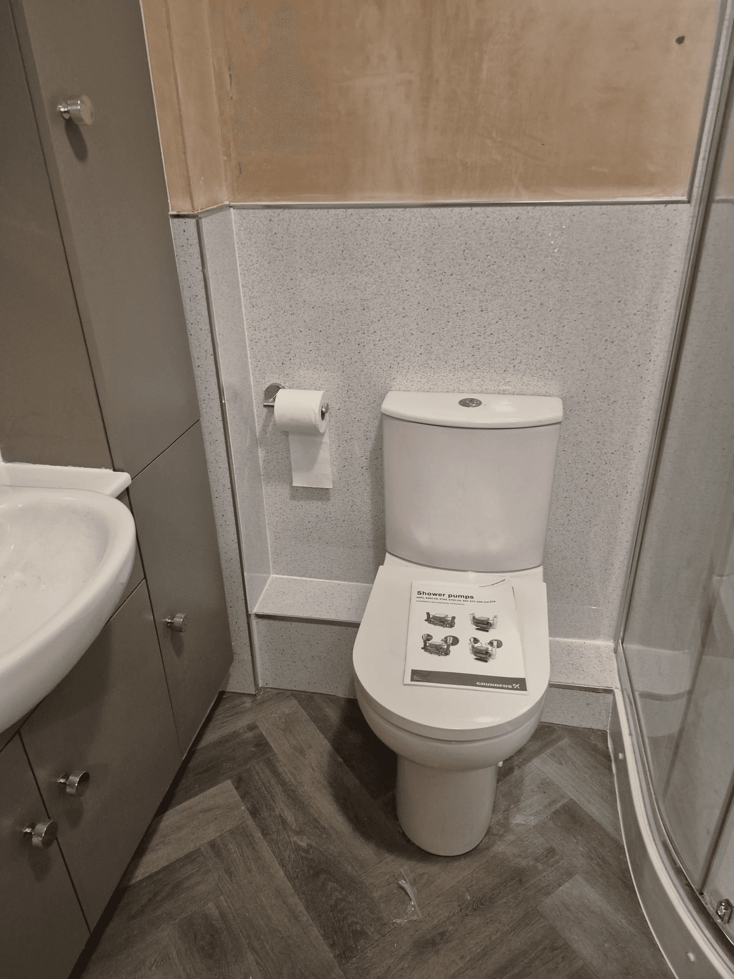 Compact shower room with toilet and herringbone floor tiles