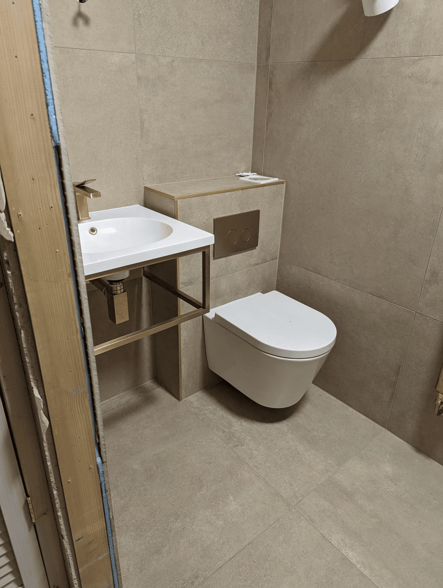 Wall-hung toilet and floating vanity unit in wetroom with large format tiles